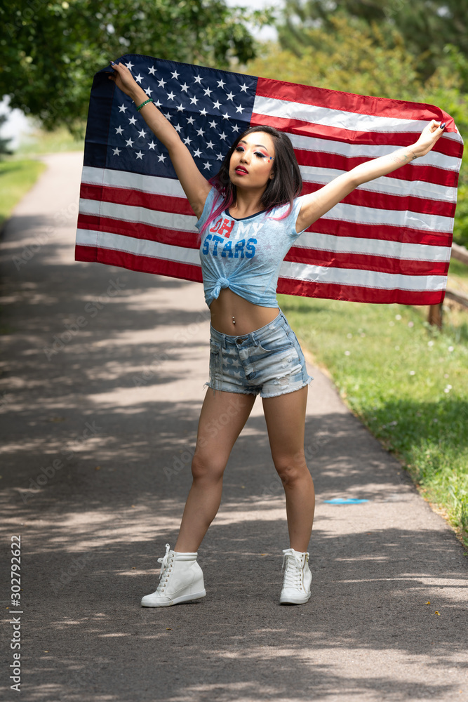 Beautiful asian girl posing with American flag in Independence Day