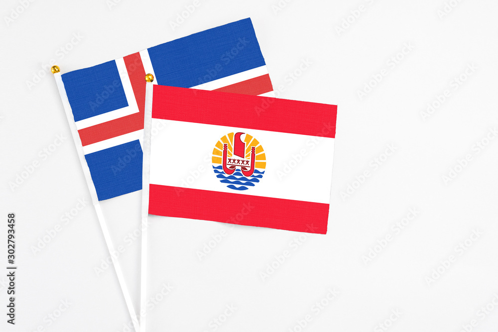 Naklejka premium French Polynesia and Iceland stick flags on white background. High quality fabric, miniature national flag. Peaceful global concept.White floor for copy space.