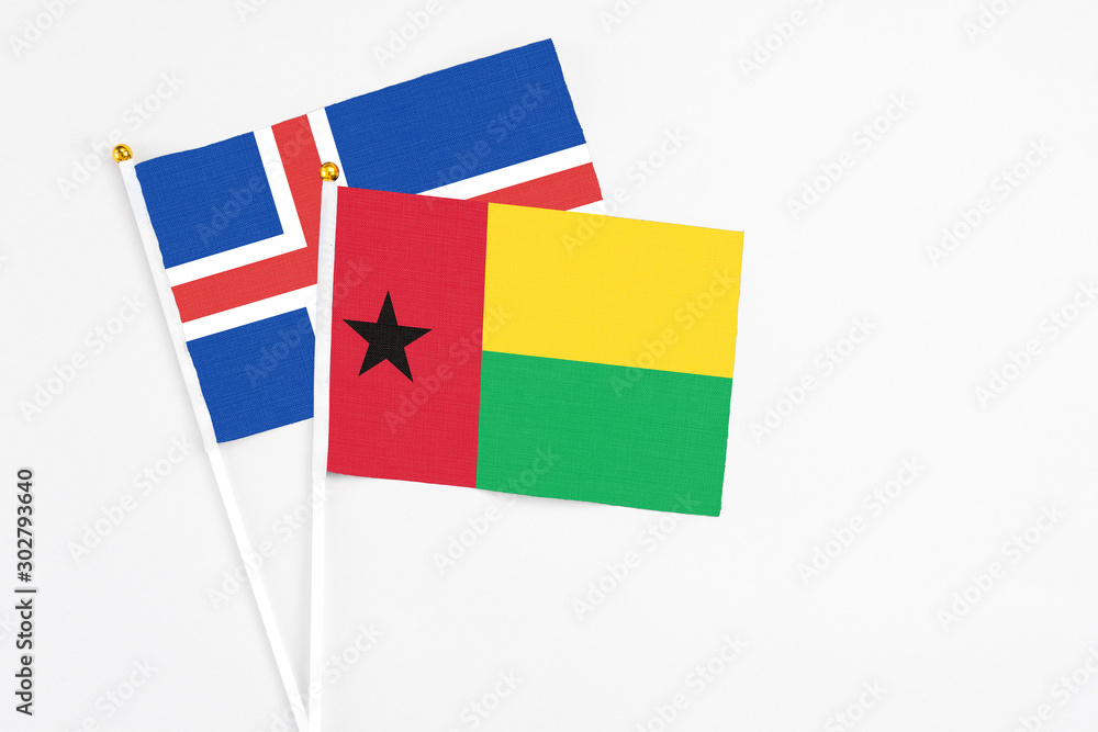 Guinea Bissau and Iceland stick flags on white background. High quality fabric, miniature national flag. Peaceful global concept.White floor for copy space. Guinea Bissau and Iceland stick flags on white background. High quality fabric, miniature national flag. Peaceful global concept.White floor for copy space.