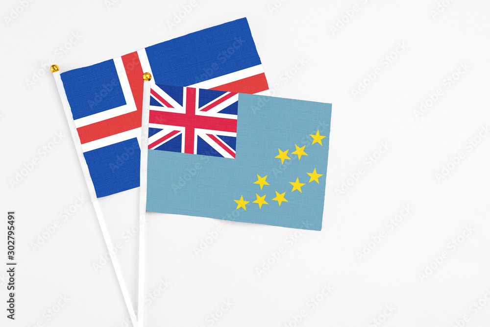 Fototapeta premium Tuvalu and Iceland stick flags on white background. High quality fabric, miniature national flag. Peaceful global concept.White floor for copy space.