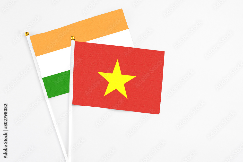 Vietnam and India stick flags on white background. High quality fabric, miniature national flag. Peaceful global concept.White floor for copy space.
