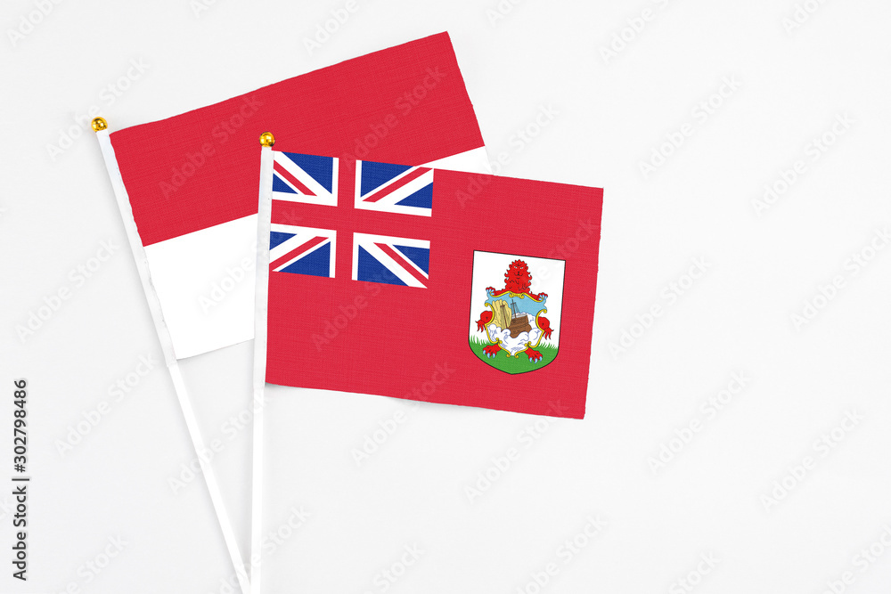 Fototapeta premium Bermuda and Indonesia stick flags on white background. High quality fabric, miniature national flag. Peaceful global concept.White floor for copy space.