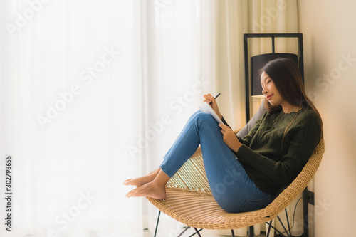 Portrait beautiful young asian women reading book and sitting on sofa chair