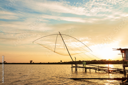 Fisherman's Fishing Tools In the lake at sunset sky background.