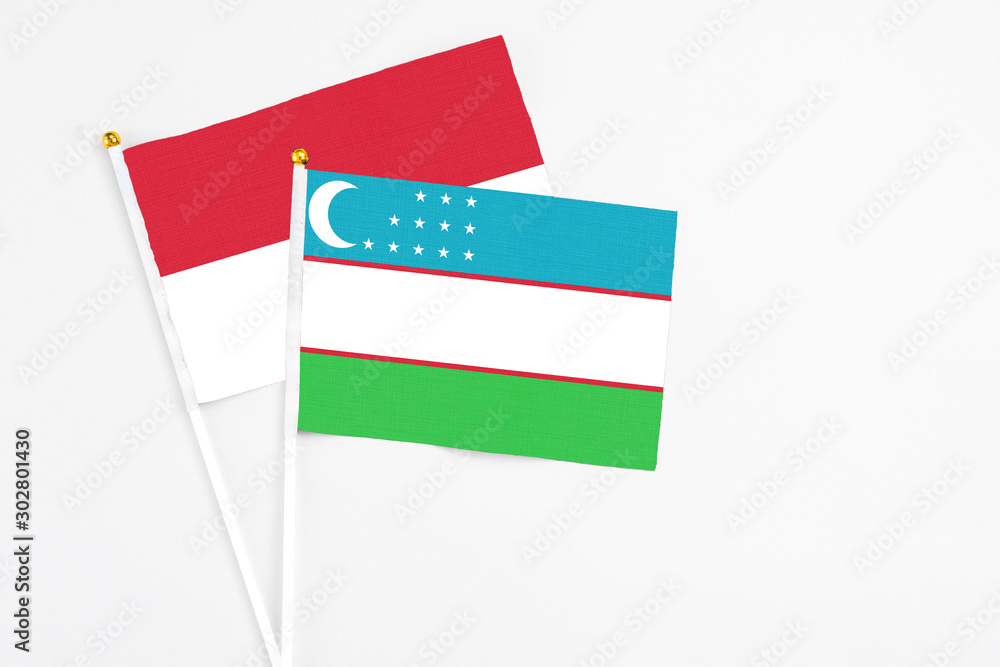 Uzbekistan and Indonesia stick flags on white background. High quality fabric, miniature national flag. Peaceful global concept.White floor for copy space. Uzbekistan and Indonesia stick flags on white background. High quality fabric, miniature national flag. Peaceful global concept.White floor for copy space.