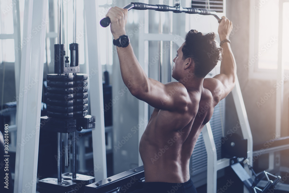 Fototapeta premium caucasian man in fitness having workout for bodybuilding with weights lifting using gym equipment
