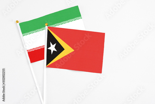 Free Download East Timor and Iran stick flags on white background. High quality fabric, miniature national flag. Peaceful global concept.White floor for copy space. - GFXLoad