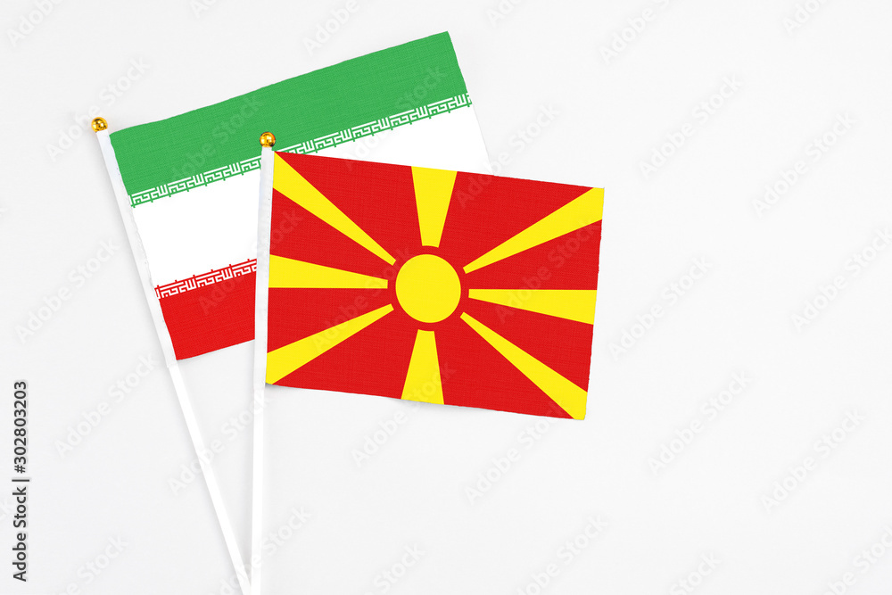 Macedonia and Iran stick flags on white background. High quality fabric, miniature national flag. Peaceful global concept.White floor for copy space.