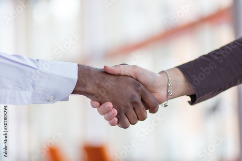 Handshake between african and a caucasian man.