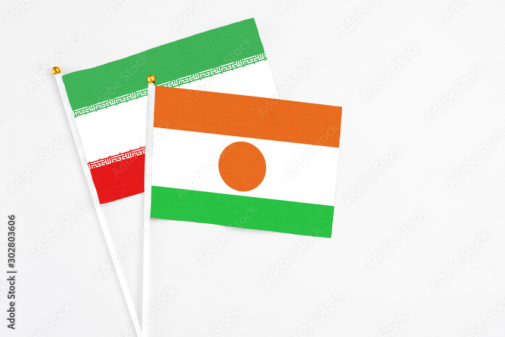 Niger and Iran stick flags on white background. High quality fabric, miniature national flag. Peaceful global concept.White floor for copy space. Niger and Iran stick flags on white background. High quality fabric, miniature national flag. Peaceful global concept.White floor for copy space.