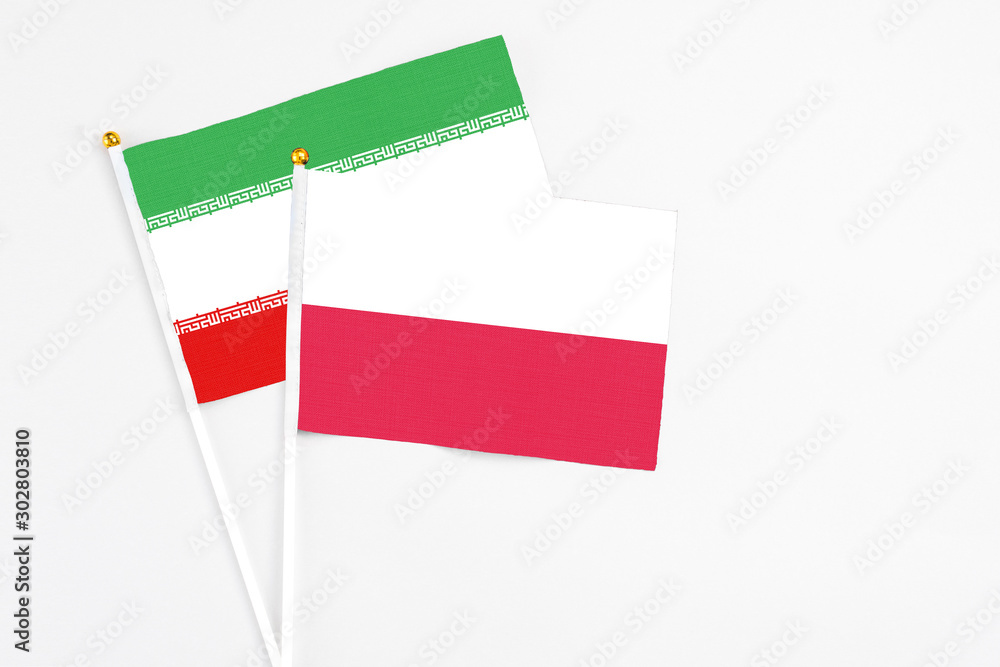 Poland and Iran stick flags on white background. High quality fabric, miniature national flag. Peaceful global concept.White floor for copy space. Poland and Iran stick flags on white background. High quality fabric, miniature national flag. Peaceful global concept.White floor for copy space.