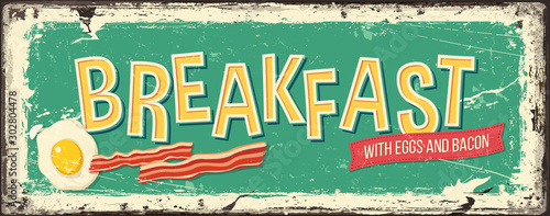 Breakfast with eggs and bacon on an old green metal background. Retro food sign design for a restaurant or a pub.