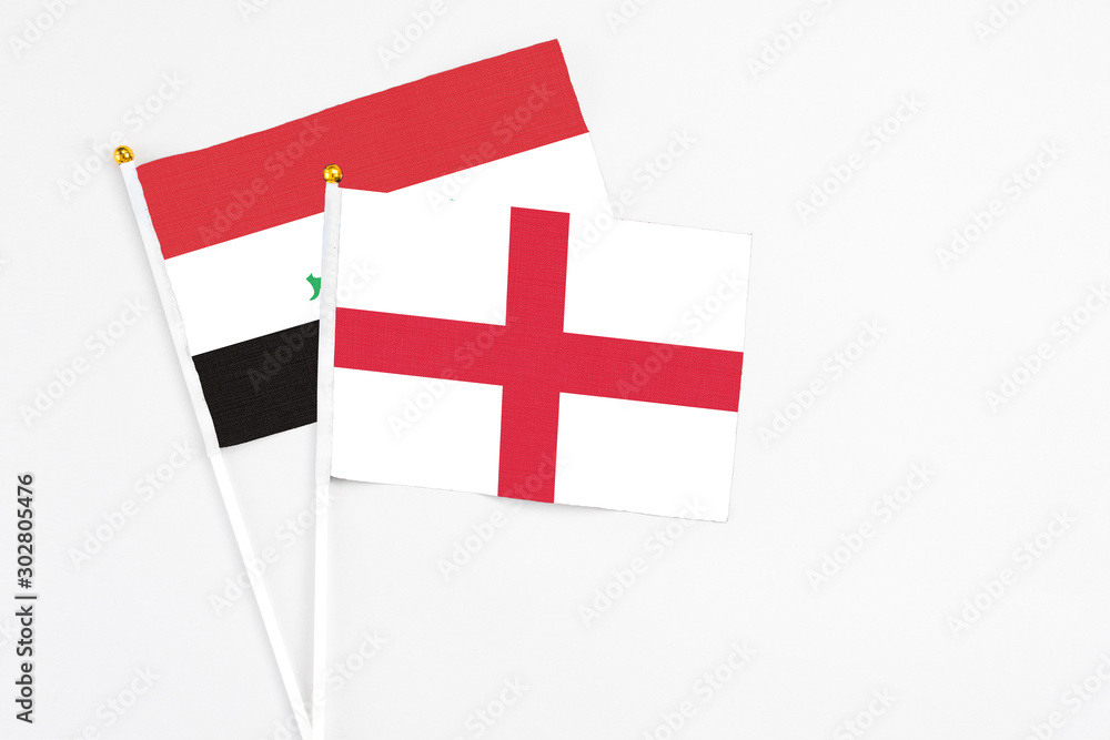 England and Iraq stick flags on white background. High quality fabric, miniature national flag. Peaceful global concept.White floor for copy space.
