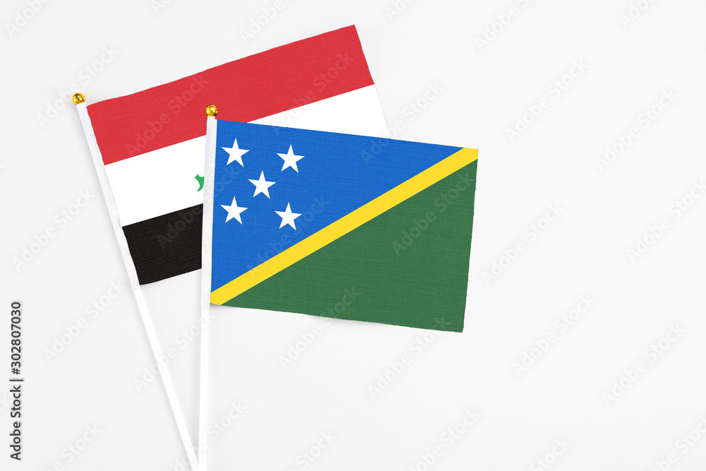 Solomon Islands and Iraq stick flags on white background. High quality fabric, miniature national flag. Peaceful global concept.White floor for copy space. Solomon Islands and Iraq stick flags on white background. High quality fabric, miniature national flag. Peaceful global concept.White floor for copy space.