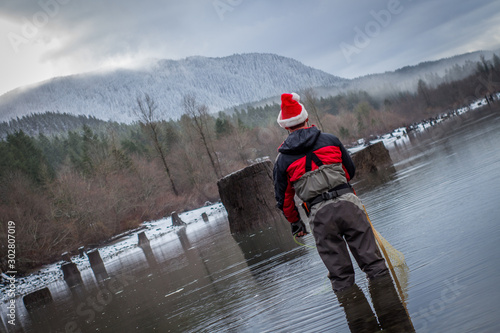 Wading Fisherman in a Santa Hat Preparing to Cast Out on the Lake - on a Cold, Winter Day