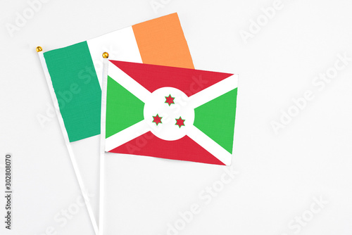 Burundi and Ireland stick flags on white background. High quality fabric, miniature national flag. Peaceful global concept.White floor for copy space photo