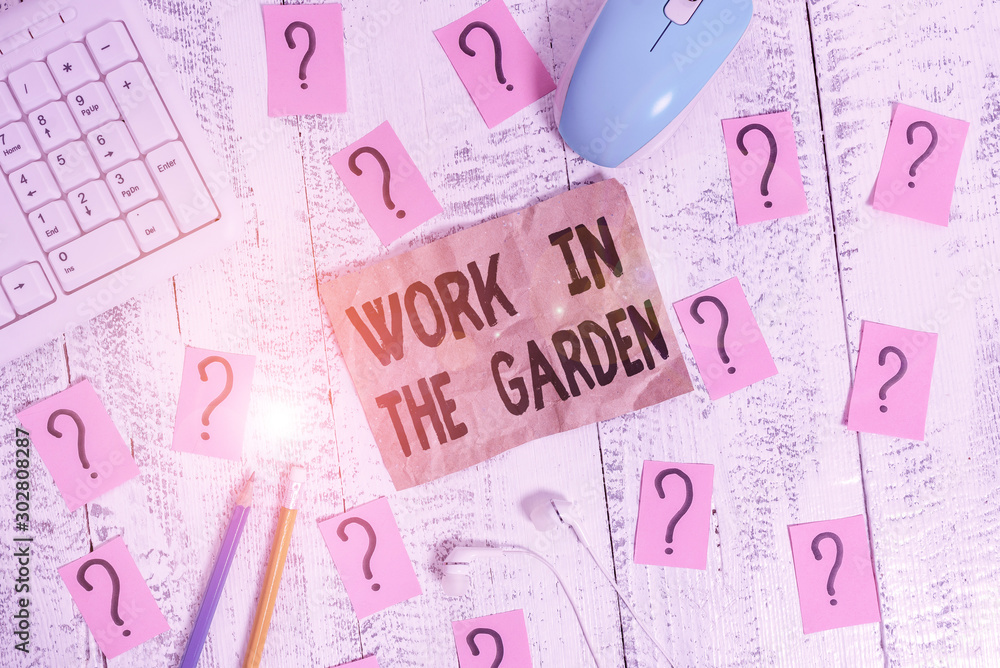 Text sign showing Work In The Garden. Business photo showcasing Tending the Lawn Yard Plant Seedlings and Crops Writing tools, computer stuff and scribbled paper on top of wooden table Text sign showing Work In The Garden. Business photo showcasing Tending the Lawn Yard Plant Seedlings and Crops Writing tools, computer stuff and scribbled paper on top of wooden table
