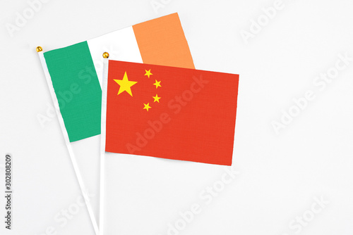 China and Ireland stick flags on white background. High quality fabric, miniature national flag. Peaceful global concept.White floor for copy space photo