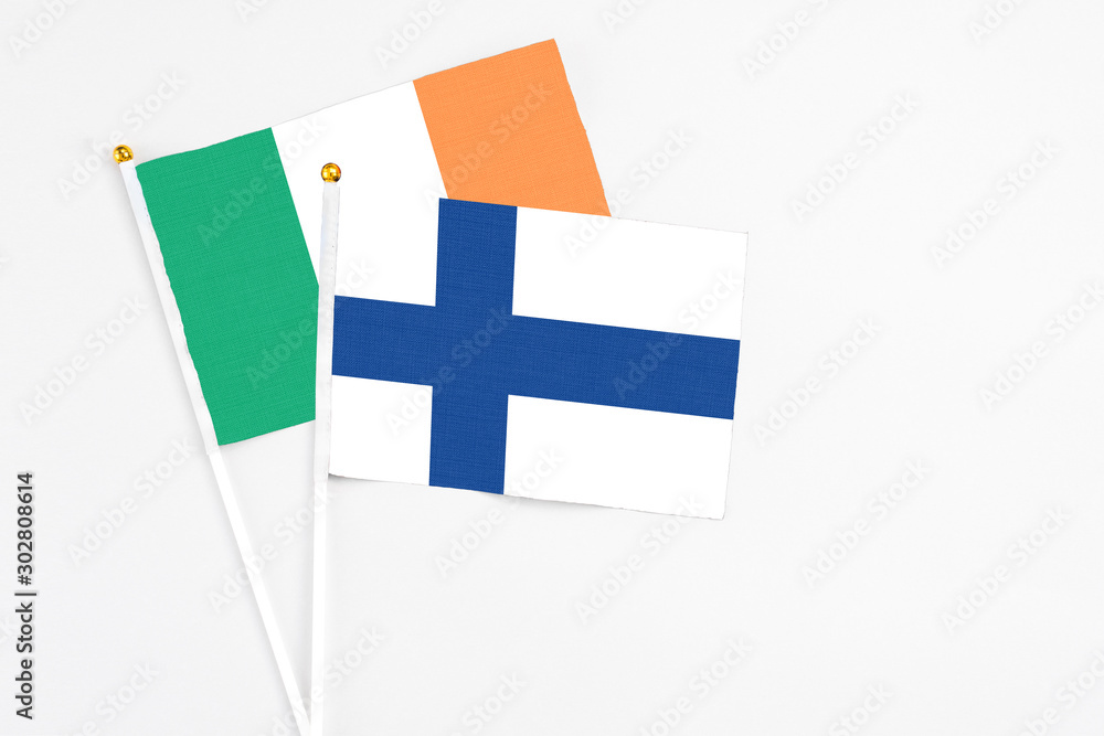 Finland and Ireland stick flags on white background. High quality fabric, miniature national flag. Peaceful global concept.White floor for copy space