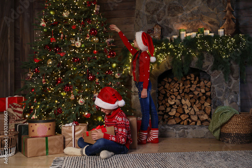Children near beautiful Christmas tree at home