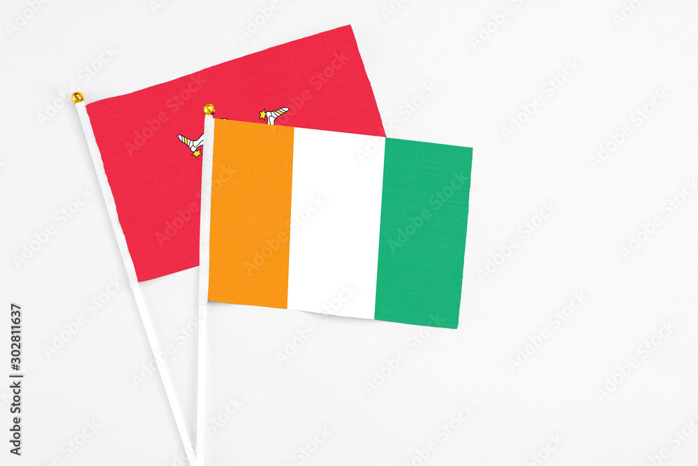 Cote D'Ivoire and Isle Of Man stick flags on white background. High quality fabric, miniature national flag. Peaceful global concept.White floor for copy space. Cote D'Ivoire and Isle Of Man stick flags on white background. High quality fabric, miniature national flag. Peaceful global concept.White floor for copy space.