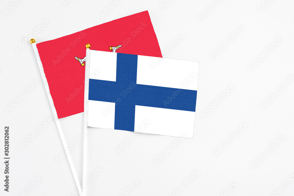 Finland and Isle Of Man stick flags on white background. High quality fabric, miniature national flag. Peaceful global concept.White floor for copy space.