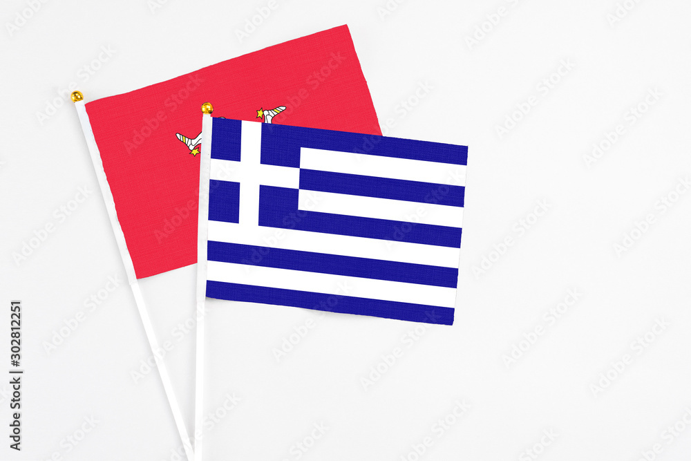 Obraz premium Greece and Isle Of Man stick flags on white background. High quality fabric, miniature national flag. Peaceful global concept.White floor for copy space.