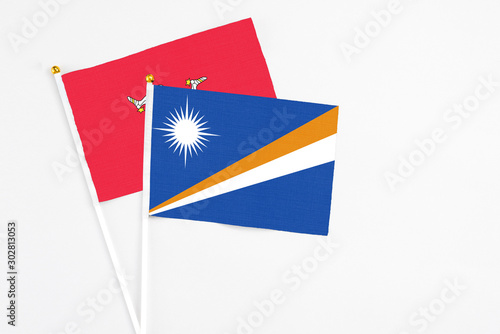 Marshall Islands and Isle Of Man stick flags on white background. High quality fabric, miniature national flag. Peaceful global concept.White floor for copy space.