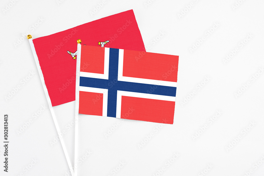 Norway and Isle Of Man stick flags on white background. High quality fabric, miniature national flag. Peaceful global concept.White floor for copy space.
