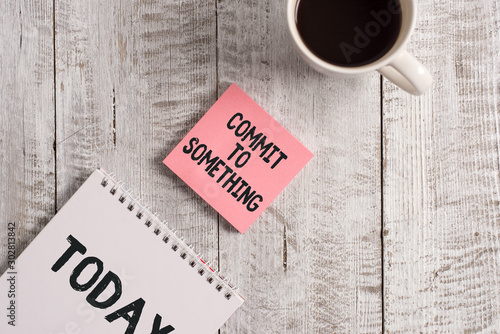Word writing text Commit To Something. Business photo showcasing To Live a Life of Purpose with Pride Honor a Promise Stationary placed next to a cup of black coffee above the wooden table