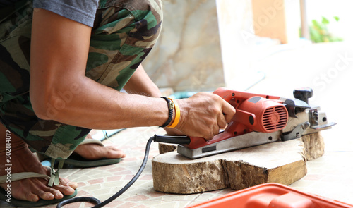 wood working with electric planer for chopping board in the carpentry workshop