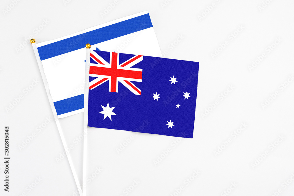 Fototapeta premium Australia and Israel stick flags on white background. High quality fabric, miniature national flag. Peaceful global concept.White floor for copy space.