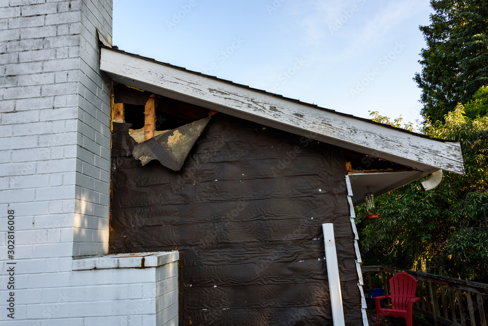 Siding project, outside of house with old siding removed, black weatherproof paper peeling off Siding project, outside of house with old siding removed, black weatherproof paper peeling off