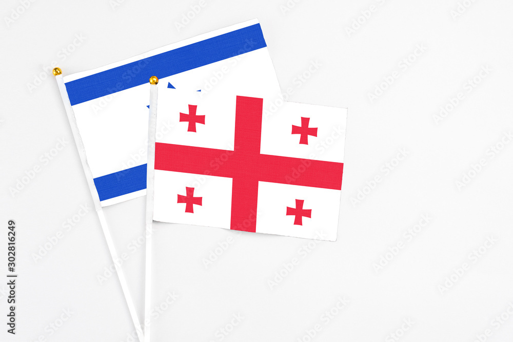 Georgia and Israel stick flags on white background. High quality fabric, miniature national flag. Peaceful global concept.White floor for copy space.