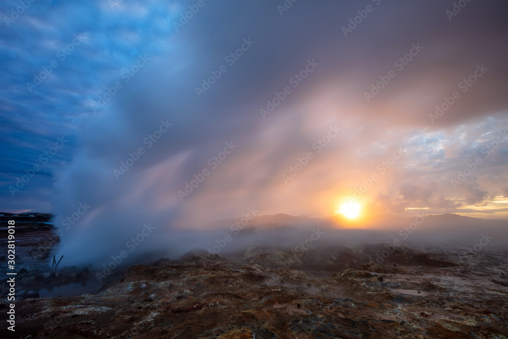 Summer Solstice Geothermal Midnight Sun Geothermal hot vent at midnight during summer solstice in the Reykjanes peninsula in the South west of Iceland with the sun rising behind the smoke