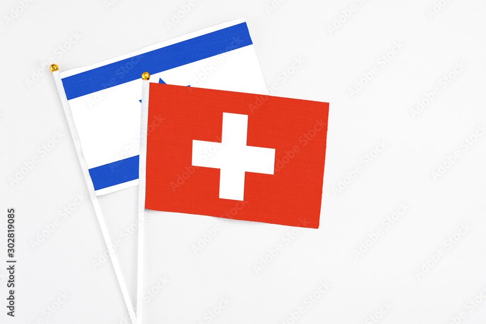 Switzerland and Israel stick flags on white background. High quality fabric, miniature national flag. Peaceful global concept.White floor for copy space.