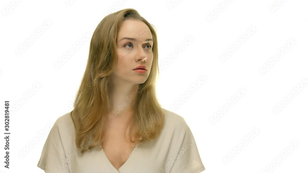 Seriouse woman looking to the right upper side and than straight to the camera. Studio portrait. Seriouse woman looking to the right upper side and than straight to the camera. Studio portrait.