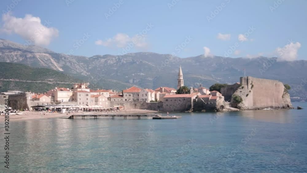 Budva old town in Montenegro on the coastline of the Adriatic Ocean on a sunny day. A pan of a viewpoint of the old town of budva and ocean Budva old town in Montenegro on the coastline of the Adriatic Ocean on a sunny day. A pan of a viewpoint of the old town of budva and ocean