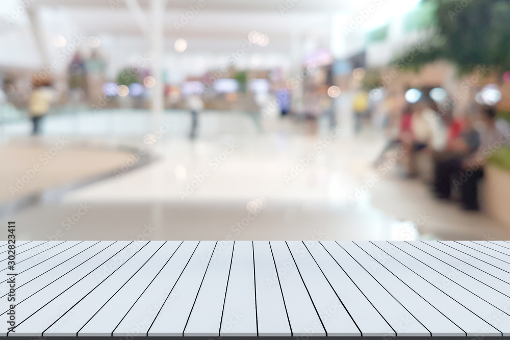 White wooden table with shopping mall blurred background