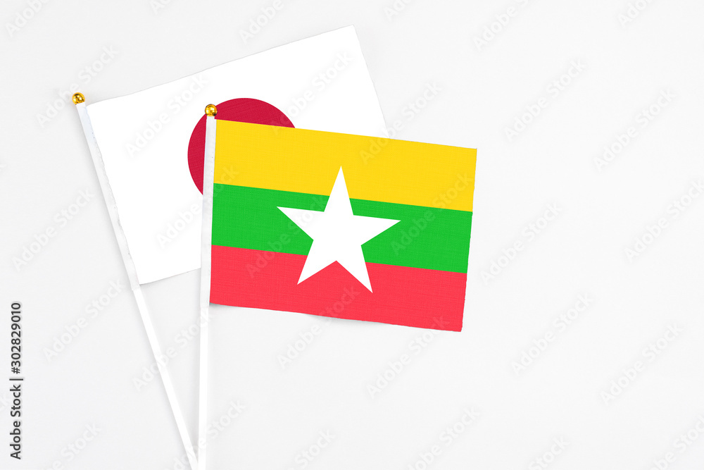 Myanmar and Japan stick flags on white background. High quality fabric, miniature national flag. Peaceful global concept.White floor for copy space. Myanmar and Japan stick flags on white background. High quality fabric, miniature national flag. Peaceful global concept.White floor for copy space.