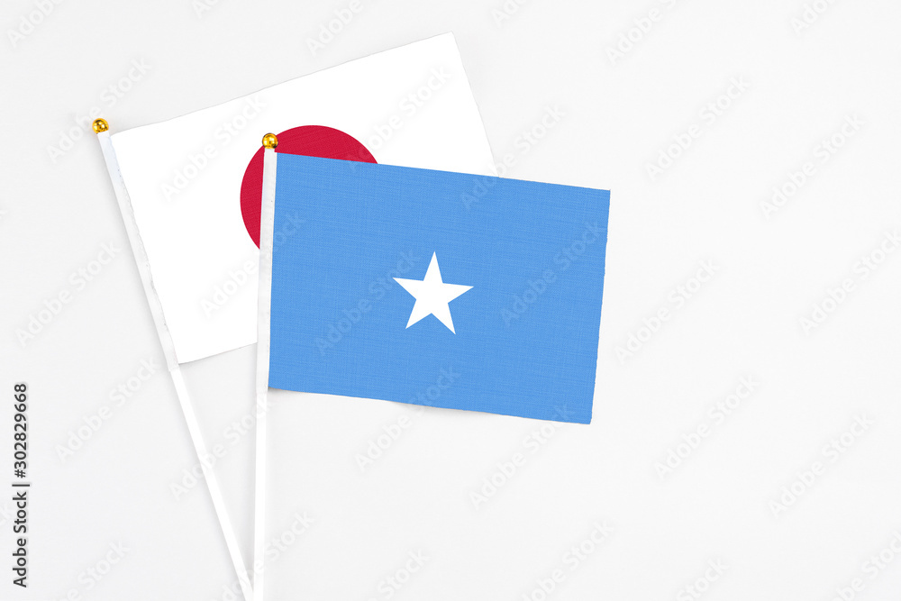Somalia and Japan stick flags on white background. High quality fabric, miniature national flag. Peaceful global concept.White floor for copy space. Somalia and Japan stick flags on white background. High quality fabric, miniature national flag. Peaceful global concept.White floor for copy space.