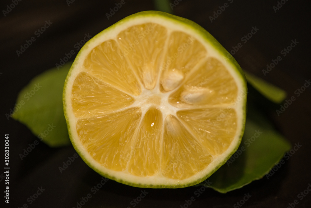 Half a lime with a bones on a black background Half a lime with a bones on a black background