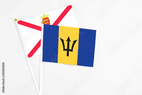Barbados and Jersey stick flags on white background. High quality fabric, miniature national flag. Peaceful global concept.White floor for copy space.