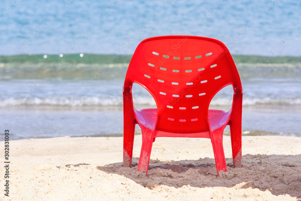 Resort background with red chair at the water's edge