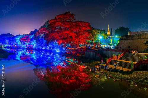 LAMPHUN, THAILAND - NOVEMBER 10, 2019 : Symphony of Lights is the spectacular light and sound show at City Wall beside the river near Wat Phra That Hariphunchai Temple for celebration in Loy Krathong 