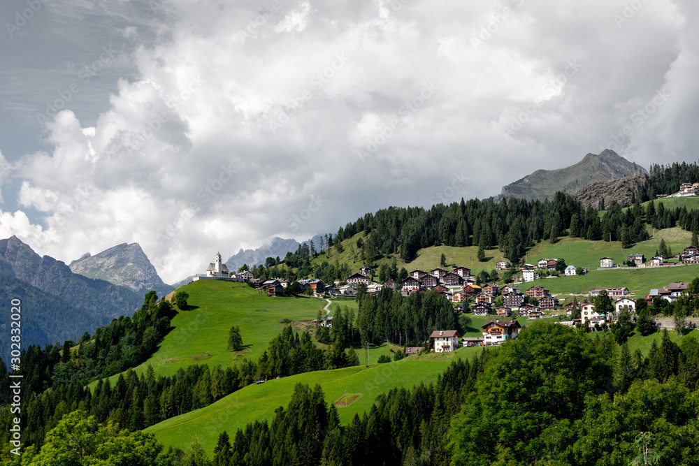View of a mountain settlement in Italy. Mountain valley of the Alps, Dolomites. Summer sunny day