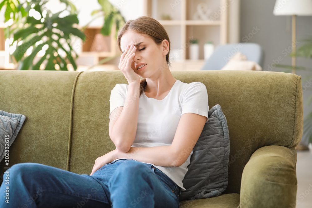 Young woman suffering from headache at home Young woman suffering from headache at home