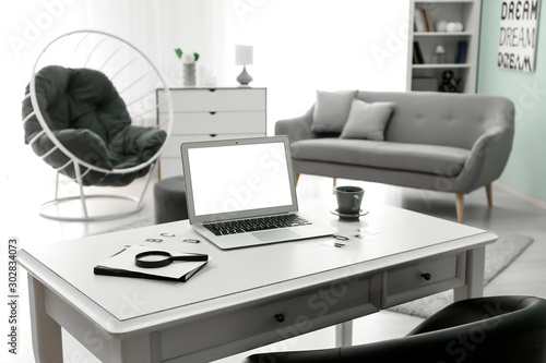 Comfortable workplace with modern laptop in room