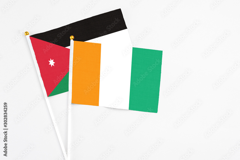 Cote D'Ivoire and Jordan stick flags on white background. High quality fabric, miniature national flag. Peaceful global concept.White floor for copy space. Cote D'Ivoire and Jordan stick flags on white background. High quality fabric, miniature national flag. Peaceful global concept.White floor for copy space.