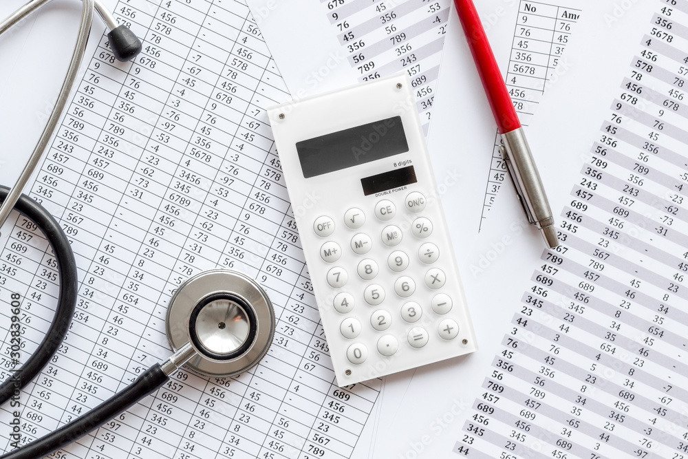 Health insurance concept. Stethoscope near financial documents and calculator top view Health insurance concept. Stethoscope near financial documents and calculator top view